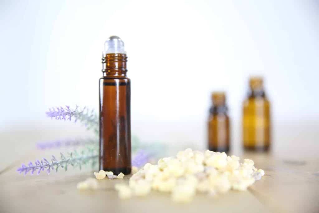 Roller bottle with essential oils for clear skin with lavender springs in background.