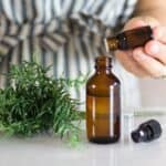 hand dropping essential oils into spray bottle