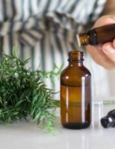 hand dropping essential oils into spray bottle