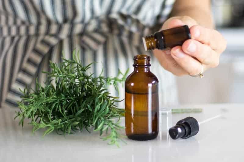 pouring essential oils into glass dropper bottle for a diy bug repellent