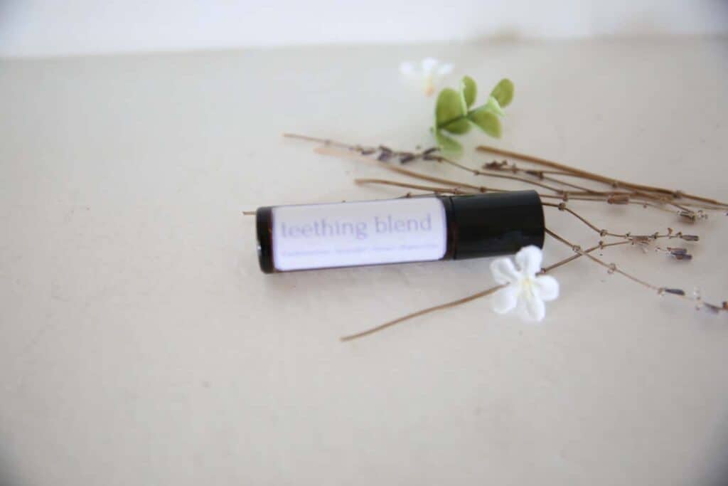 Teething roller bottle blend laying on a white marble counter.