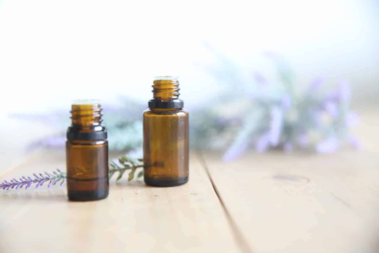 lavender essential oil dropper bottles surrounded by dried lavender sprigs