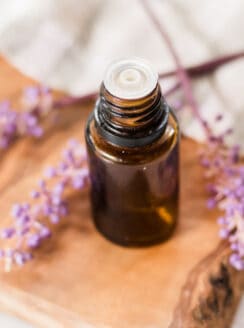 Overhead shot of lavender essential oil bottle and lavender sprigs.