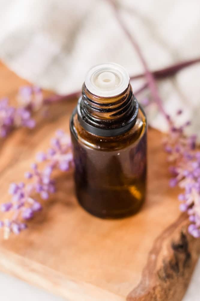 Overhead shot of lavender essential oil bottle and lavender sprigs.