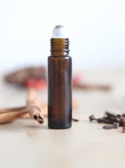 Womans roll on perfume stick with dried flowers surrounding it.