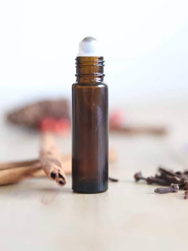 Womans roll on perfume stick with dried flowers surrounding it.