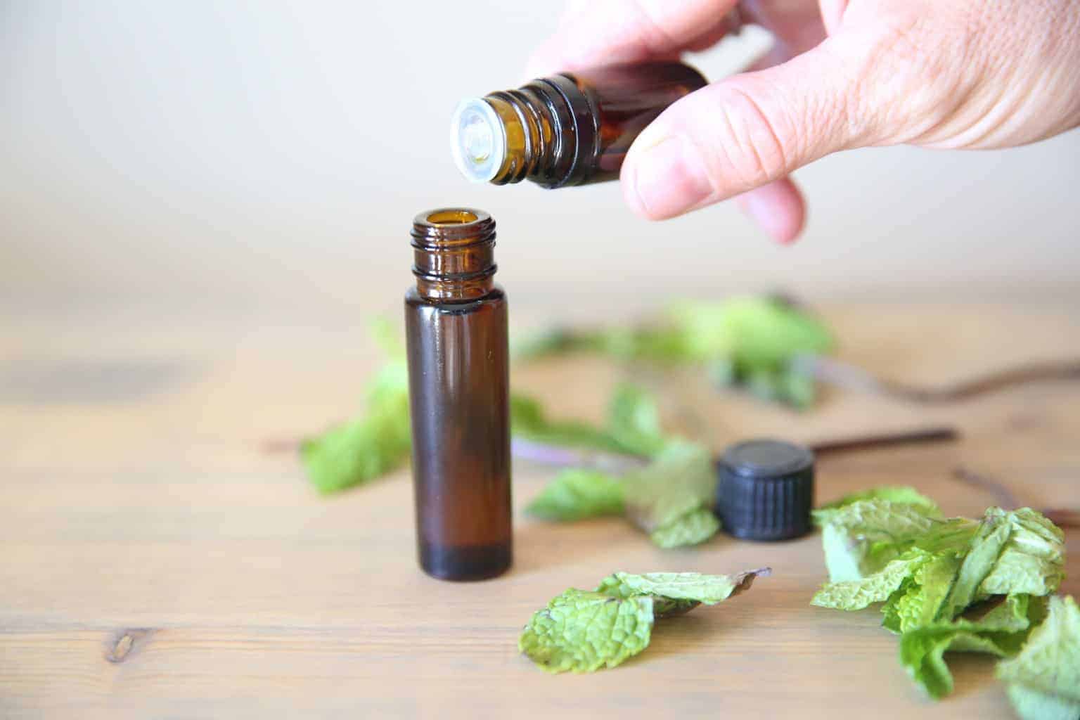 adding peppermint essential oil to a 15ml rollerball bottle