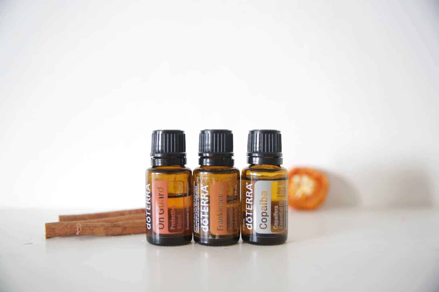 on guard frankincense and copaiba in doterra 15ml bottles on white marble