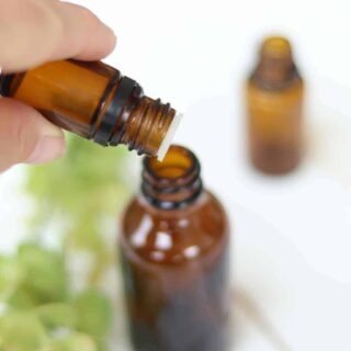 Adding essential oils to a homemade febreze spray bottle.