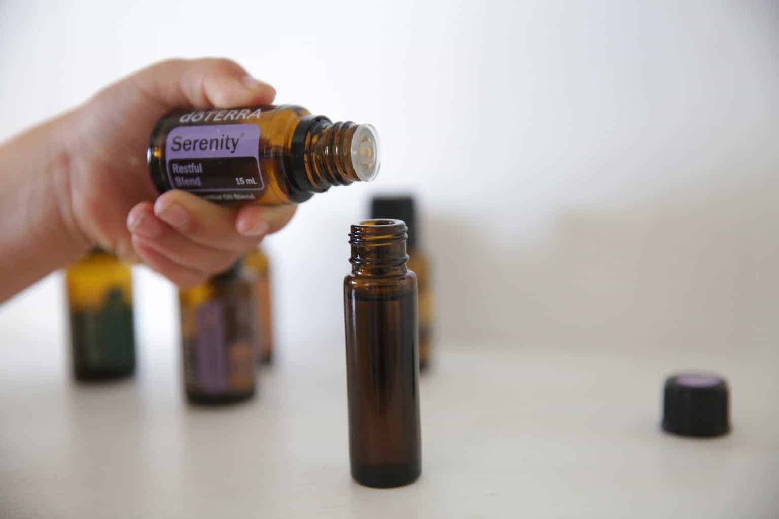 adding serenity essential oil to a sleep rollerball bottle