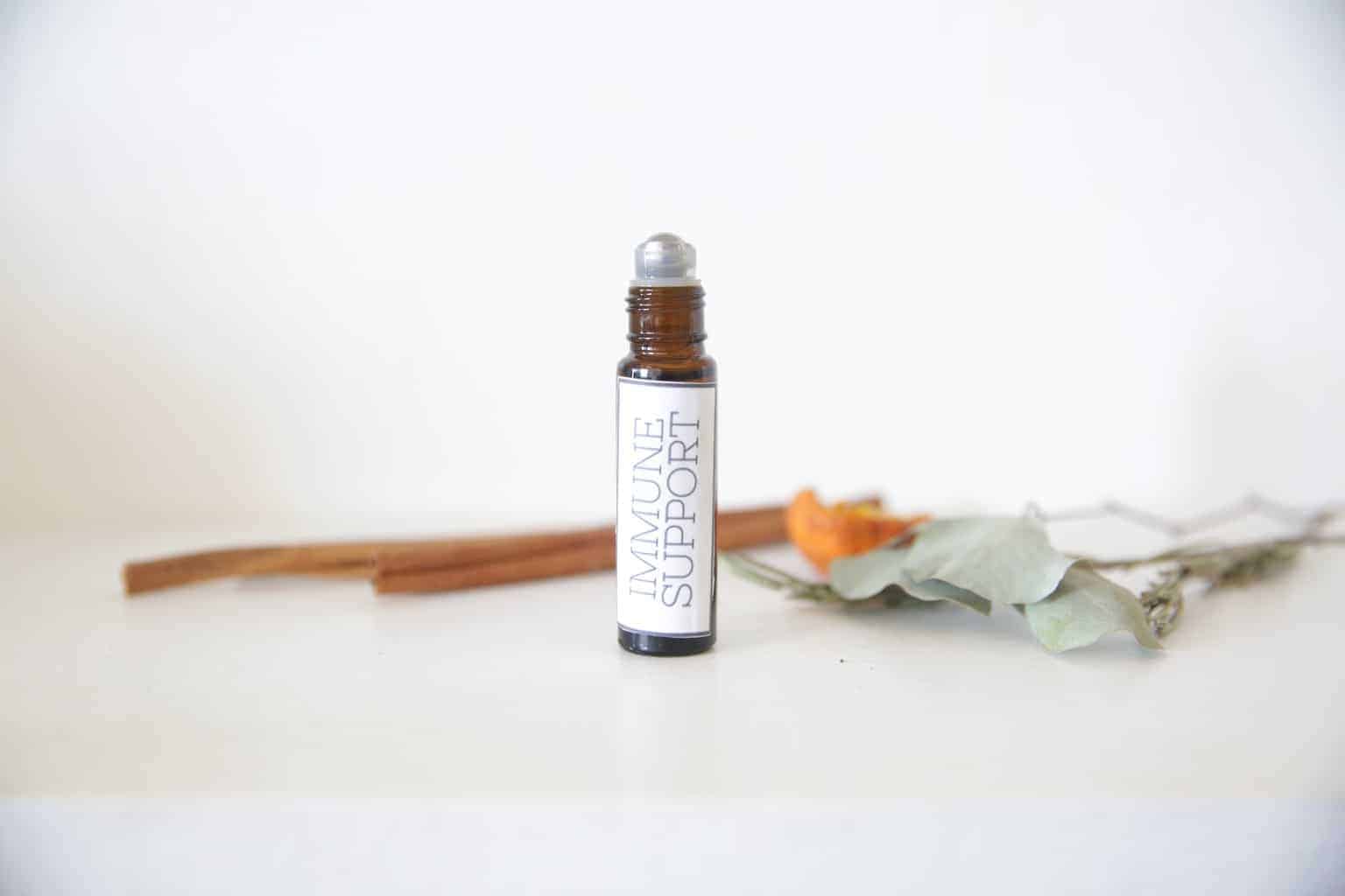 IMMUNE SUPPORT ROLLERBALL BOTTLE WITH CINNAMON STICKS ON WHITE MARBLE