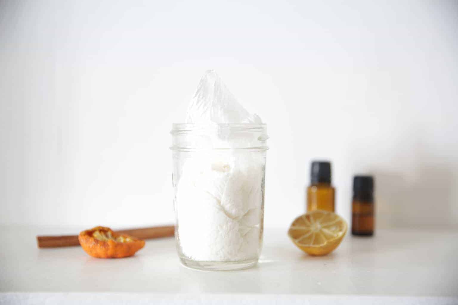 all natural homemade wipes in a small clear container with dried fruit on white marble