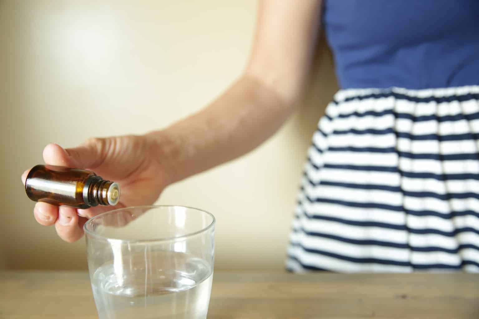 A women adding essential oils to water.