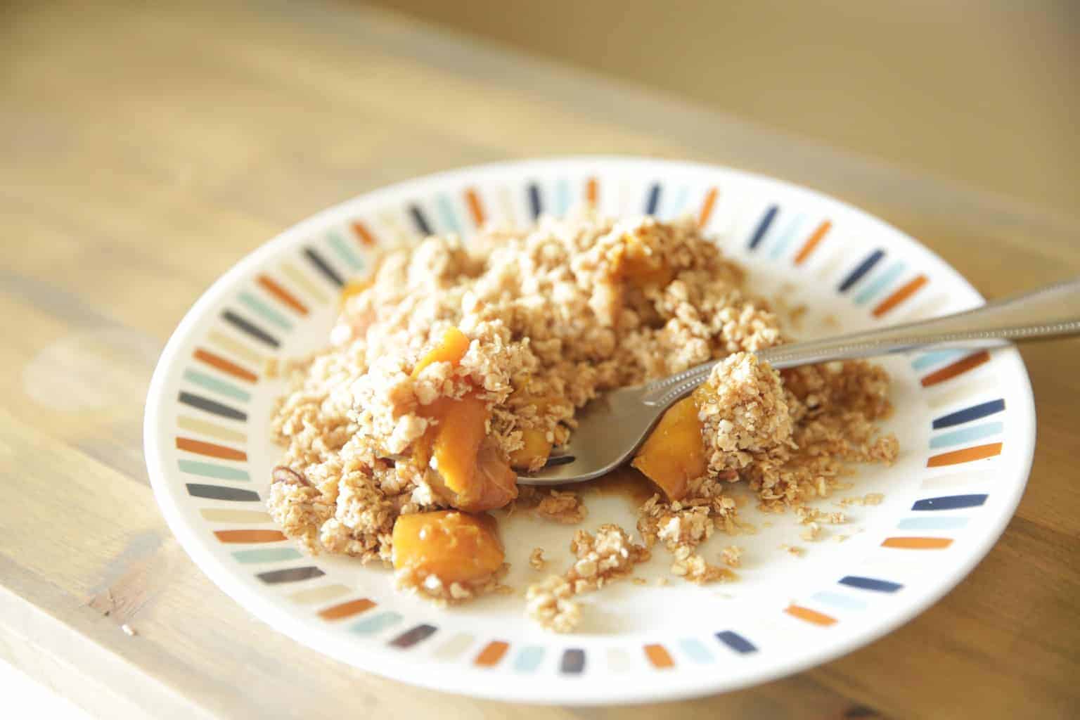 healthy peach crisp on small decorative plate