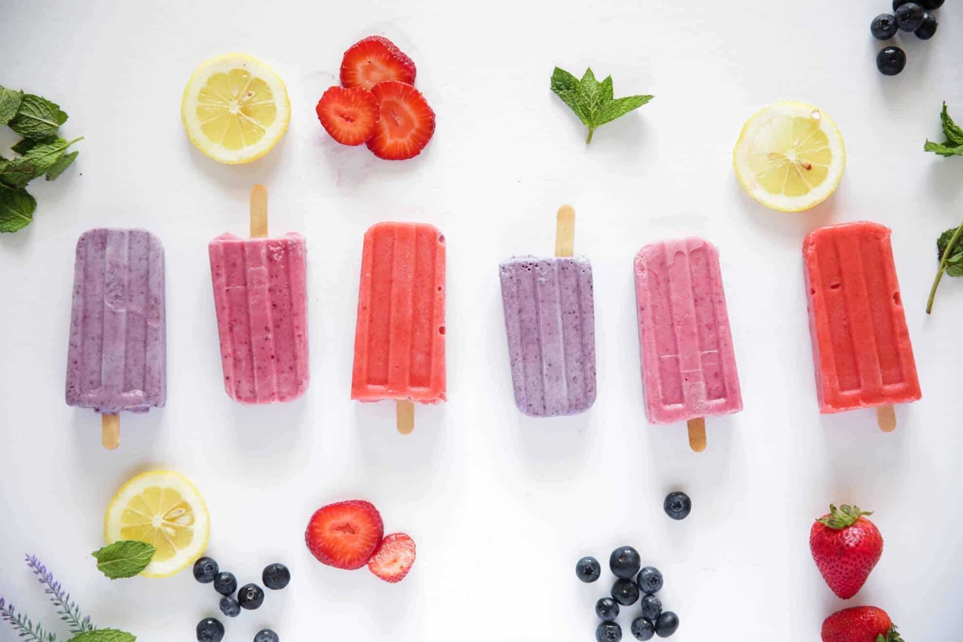 homemade real fruit popsicles on white marble