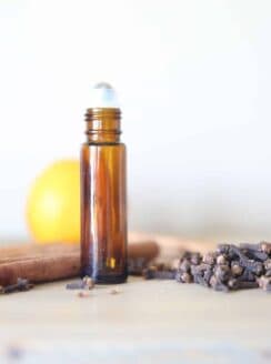 Cinnamon essential oils roller bottle with dried cinnamon.