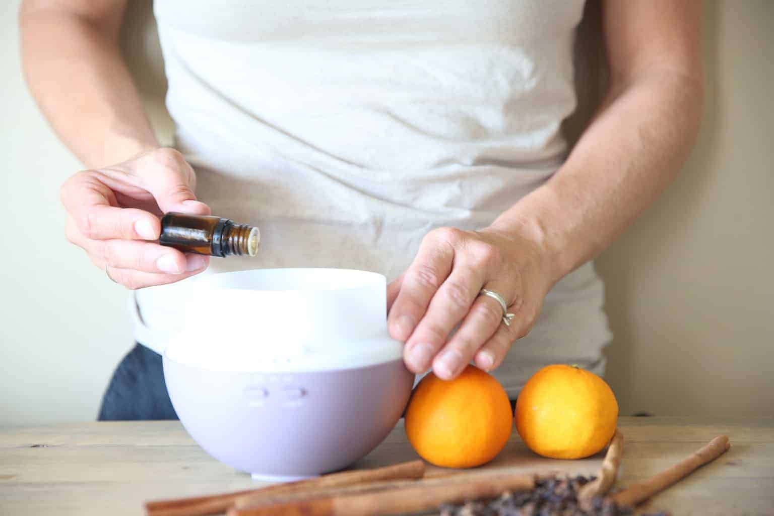 adding cinnamon essential oil to diffuser.
