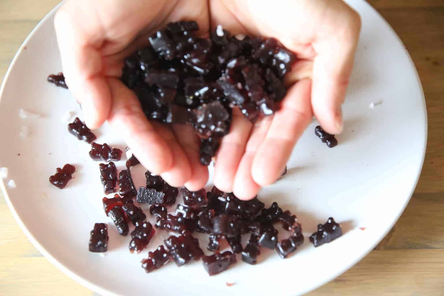 holding homemade Immune Boosting Gummy Bears above white plate