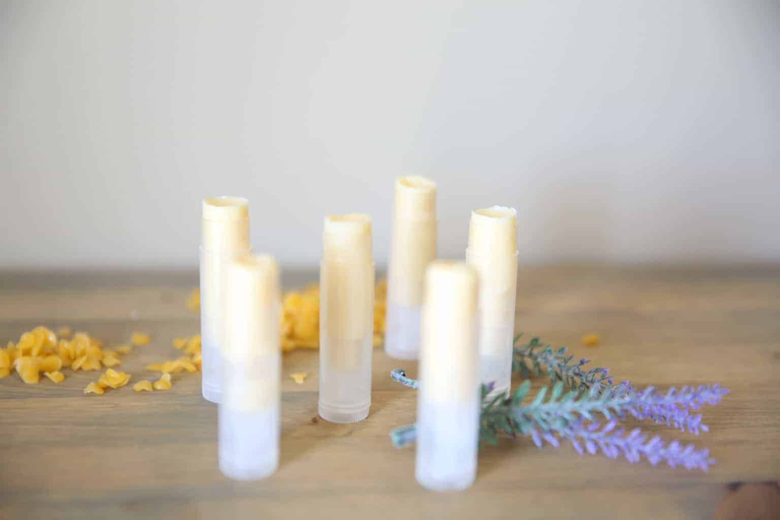 Freshly made lip balm on wooden table with dried lavender springs.