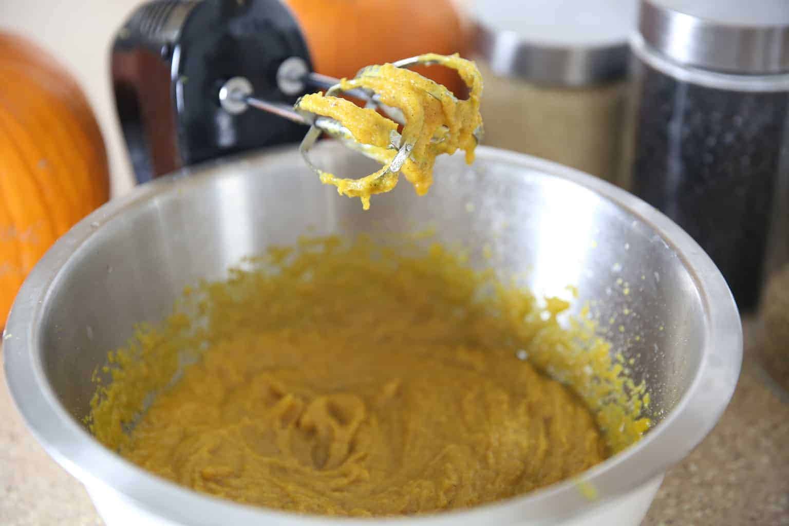 using a hand mixer to mix the pumpkin bread dough