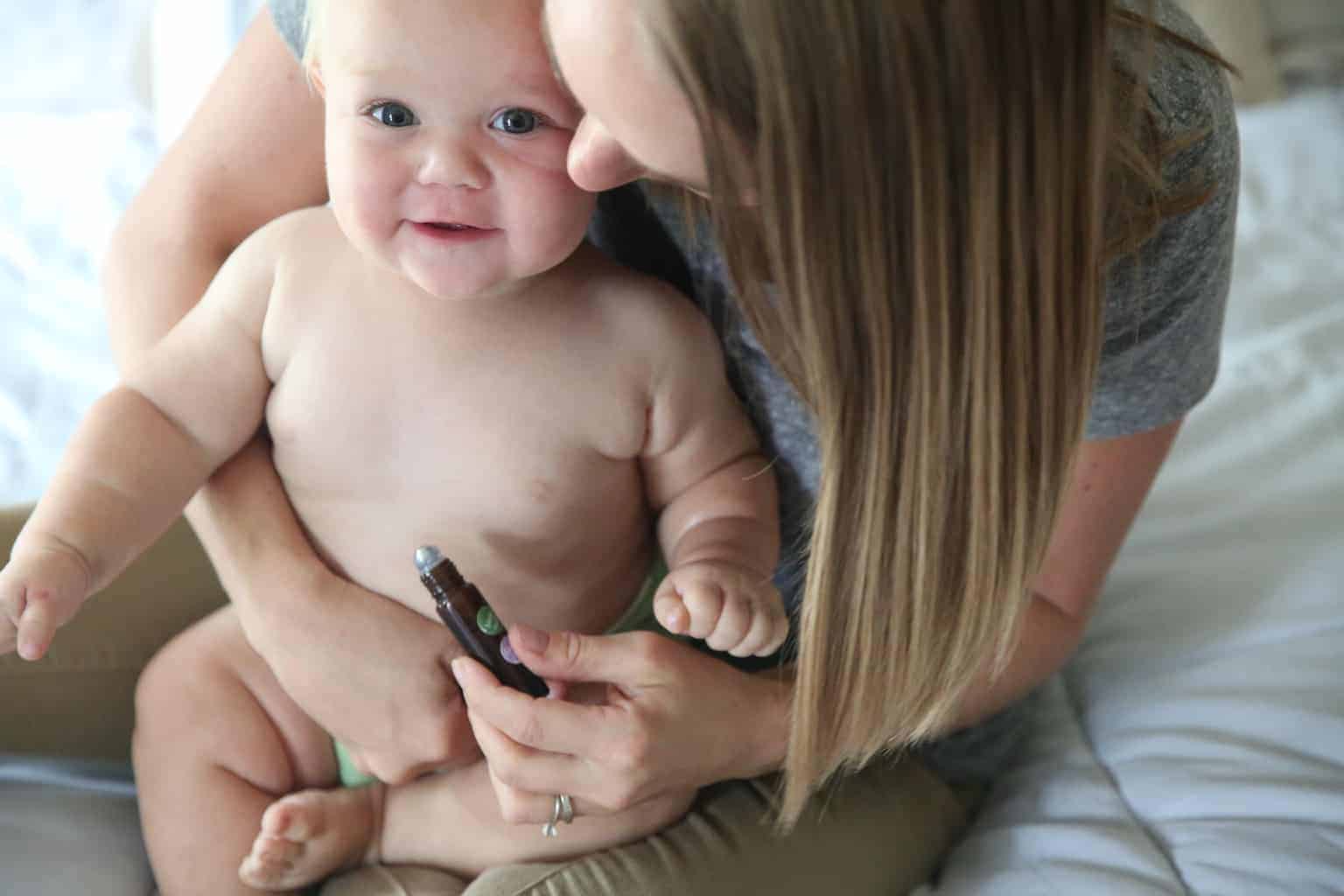 Applying essential oil roller bottle to a little tummy