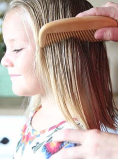 Wood comb combing through little girls hair.