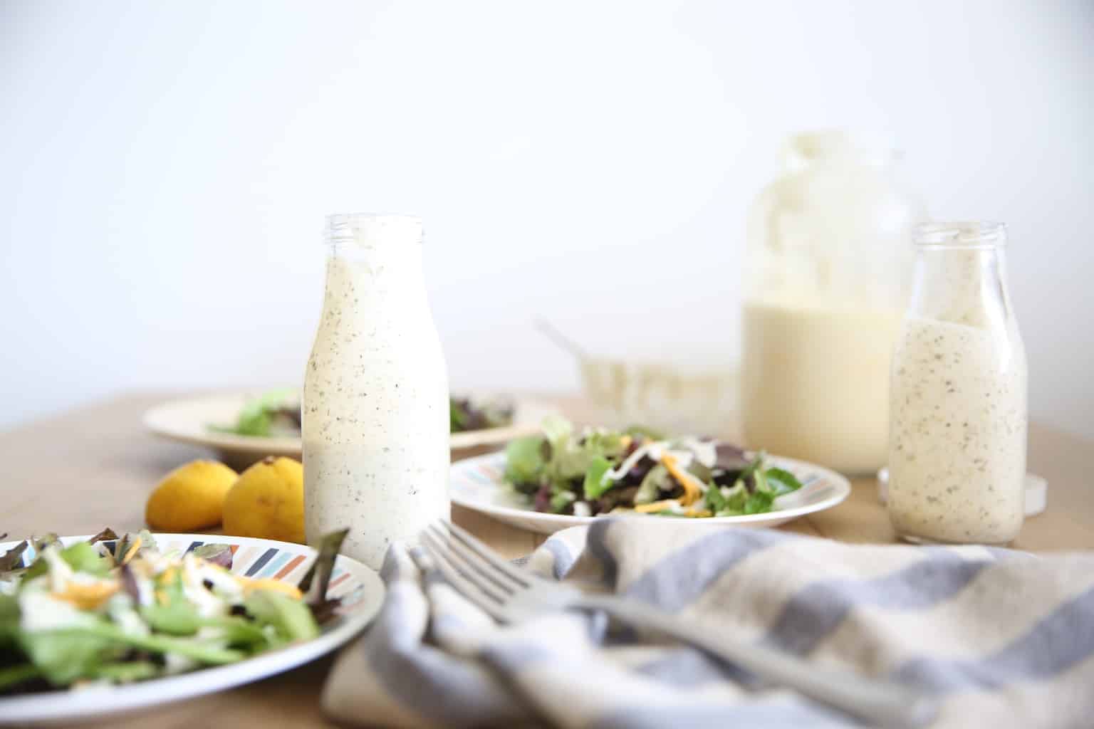 Table set with salads and greek yogurt ranch dressing.