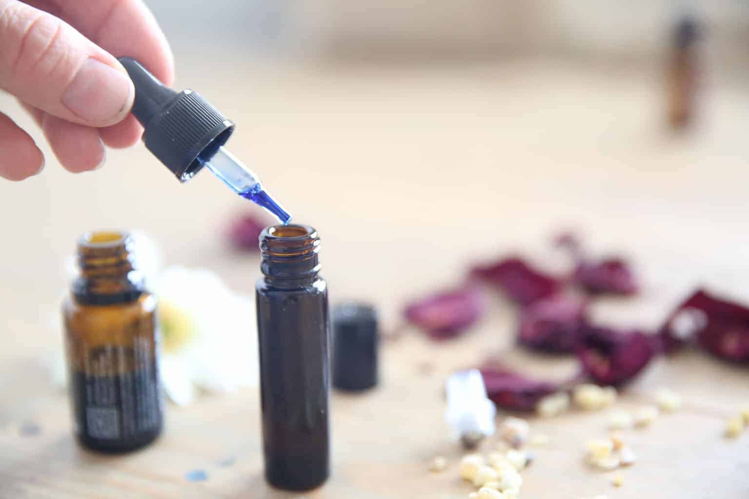 Adding essential oils to a essential oil roller bottle for scars.