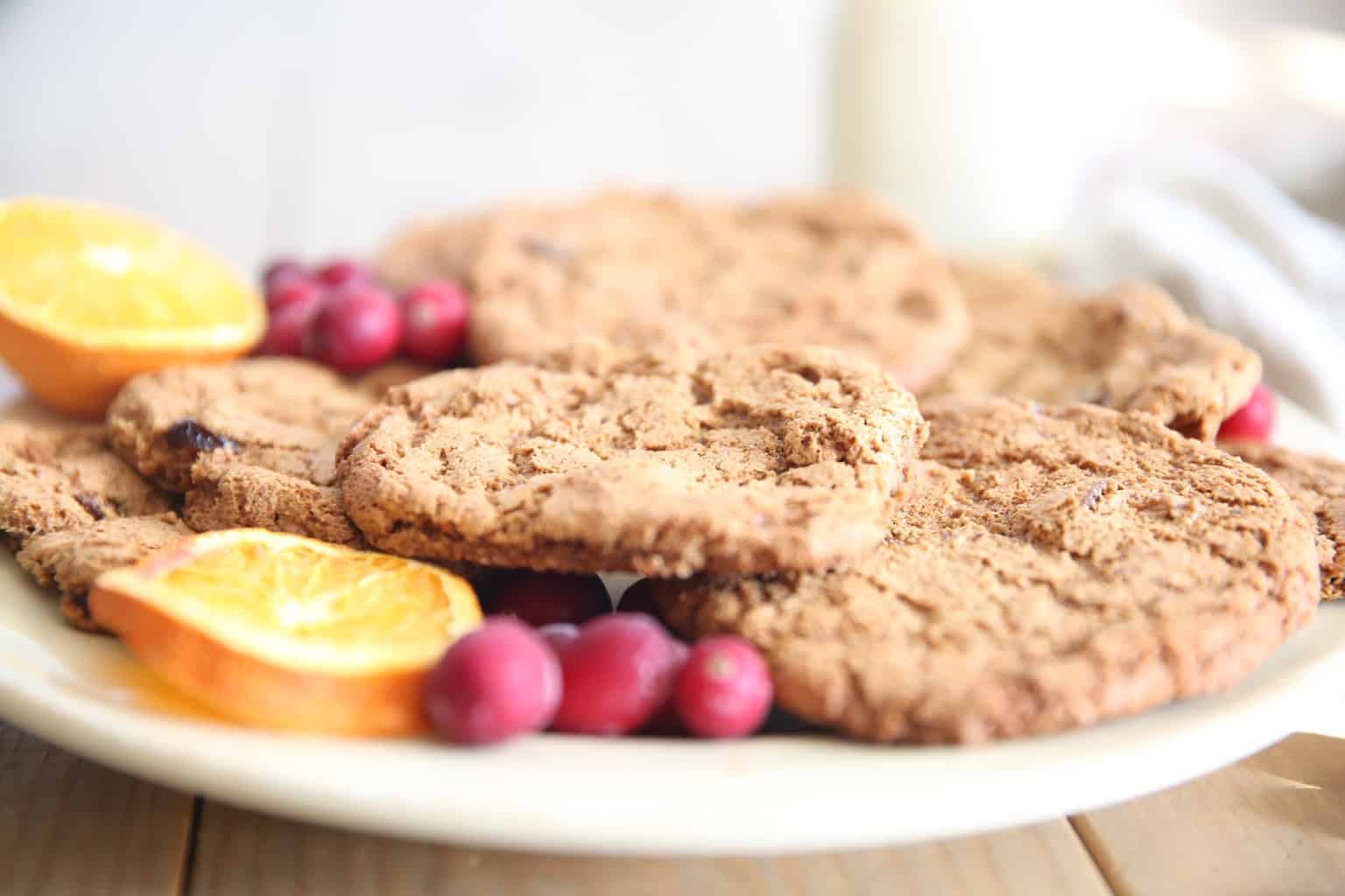 paleo cranberry cookies with dried orange and cranberries on white plate.