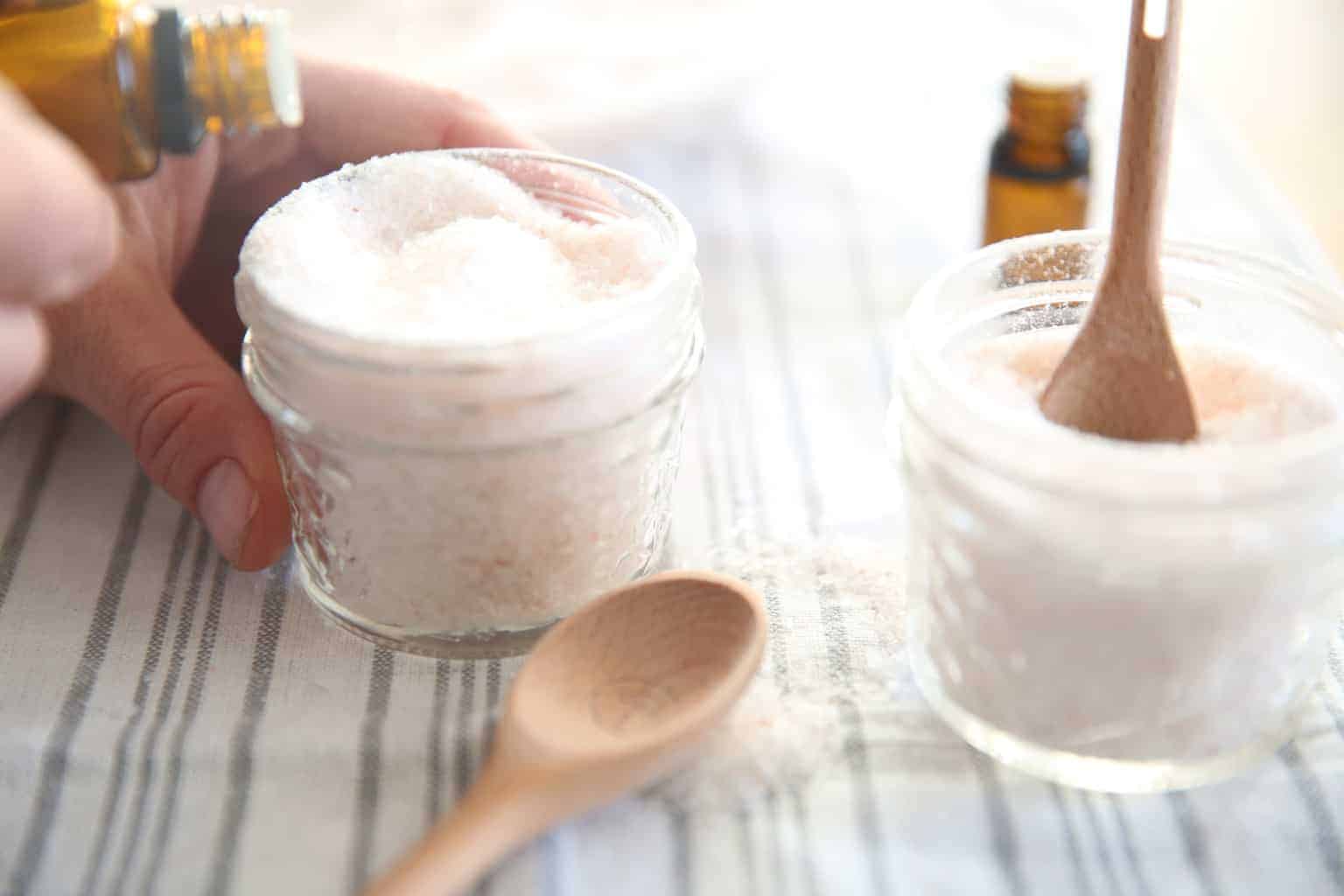 Adding essential oils to a jar of homemade bath salts.