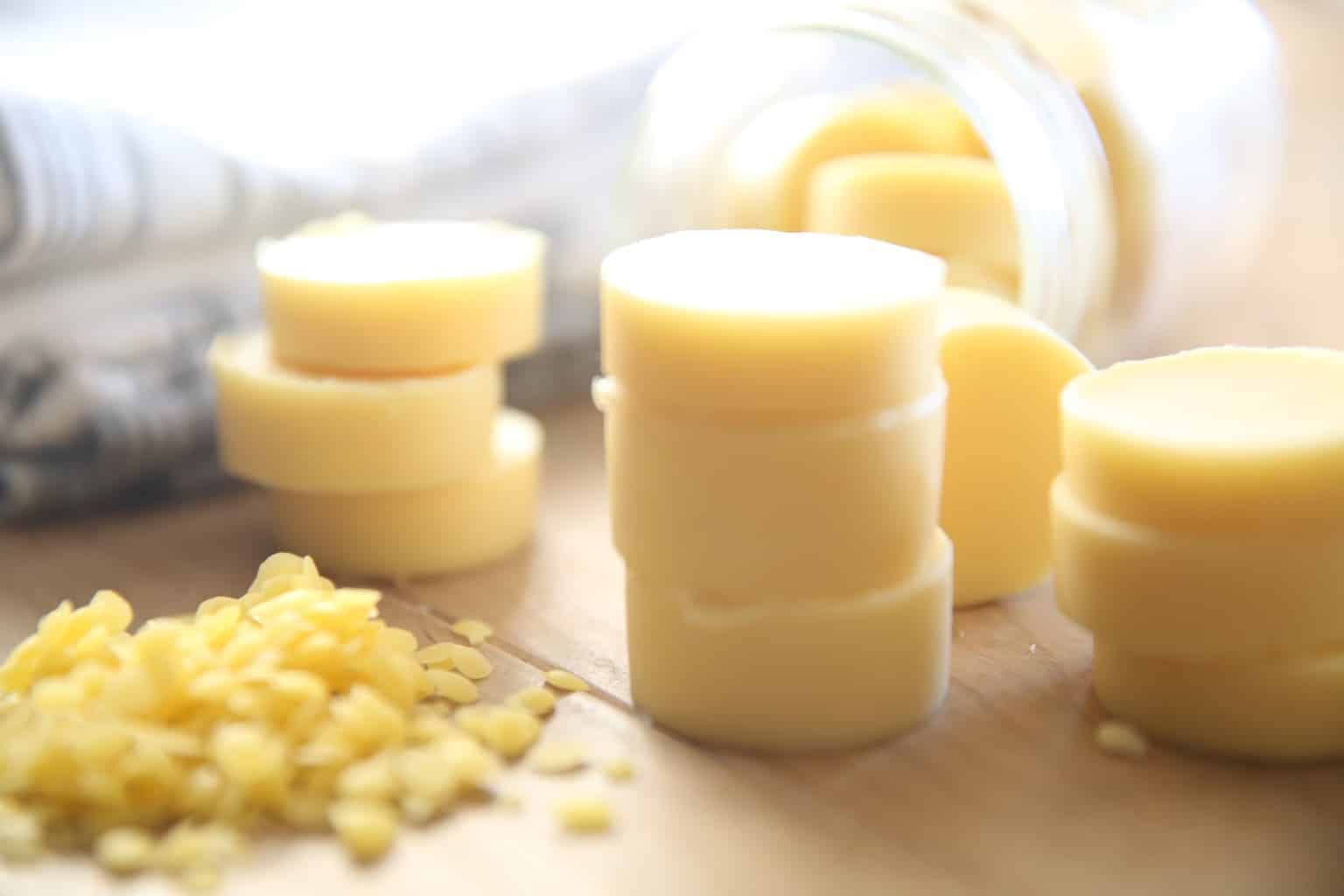 stacks of diy lotion bars with beeswax shavings next to blue and white towel