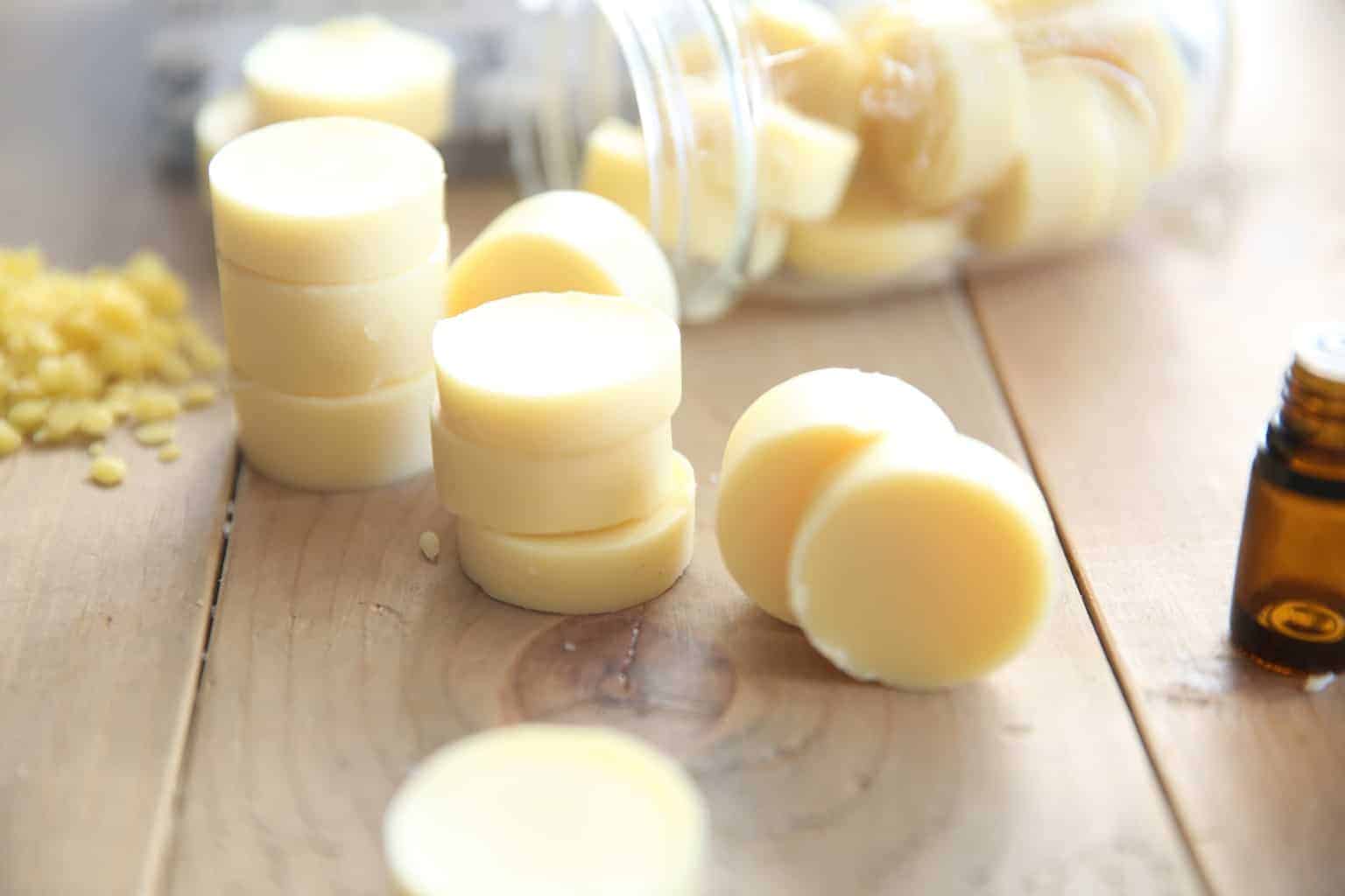 handmade lotion bars around a glass mason jar and essential oils