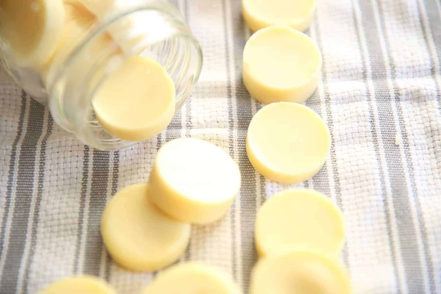 homemade lotion bars on white and gray towel in a mason jar