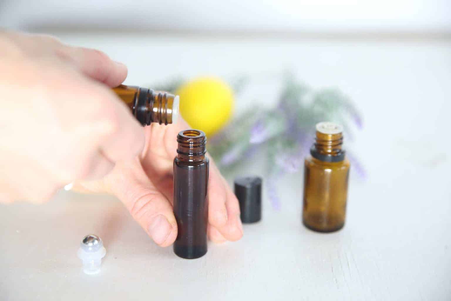 A women making seasonal allergy roller bottle with lavender and fresh lemon in the background.