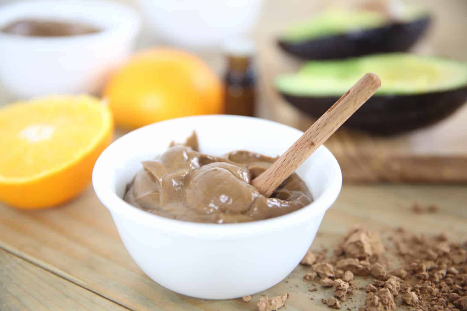 Orange chocolate pudding in bowl with ingredients in background.