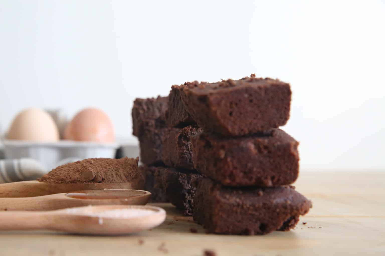 Stack of gluten-free paleo brownies on wooden table.