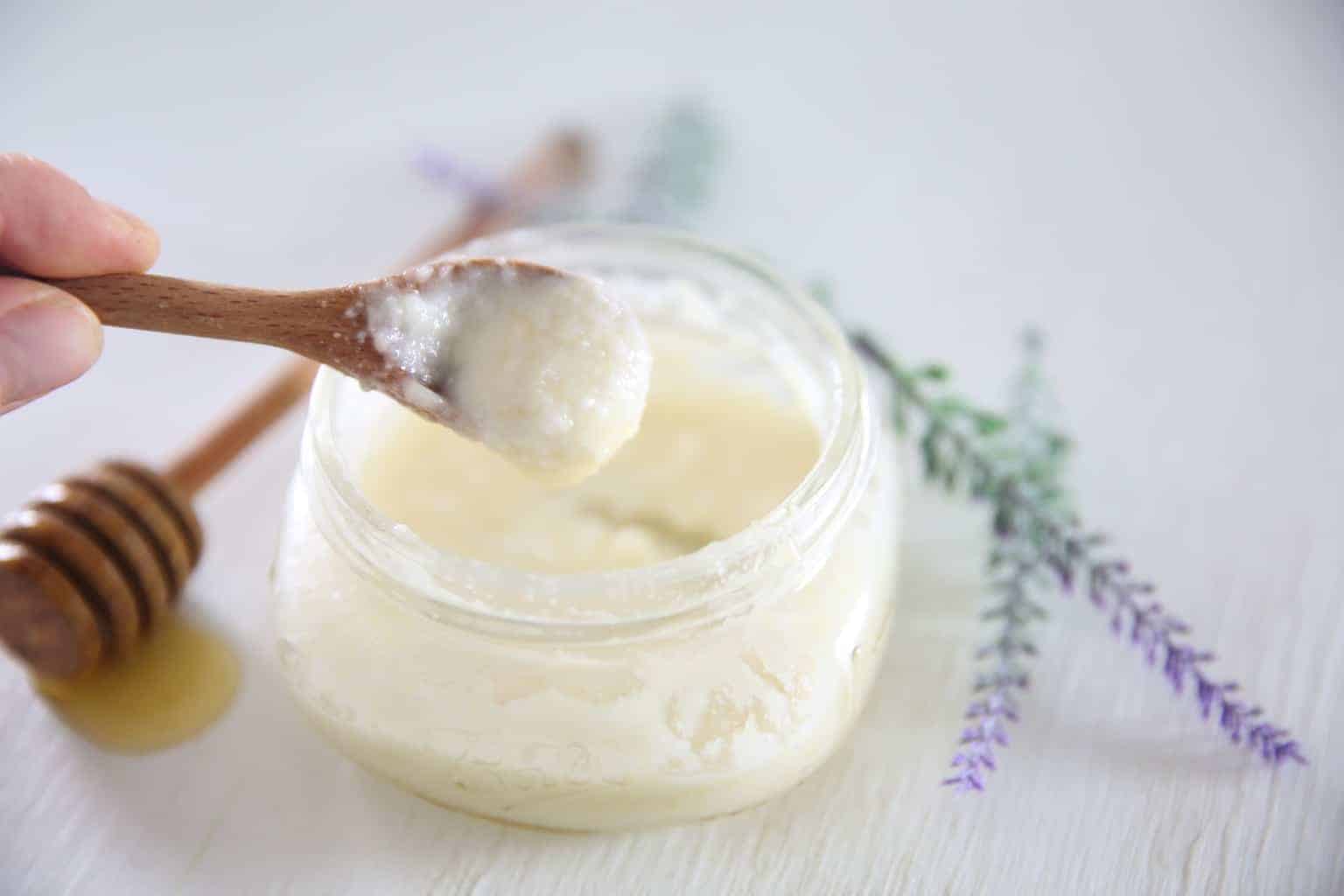 Homemade face wash in glass mason jar with honey stick and lavender.