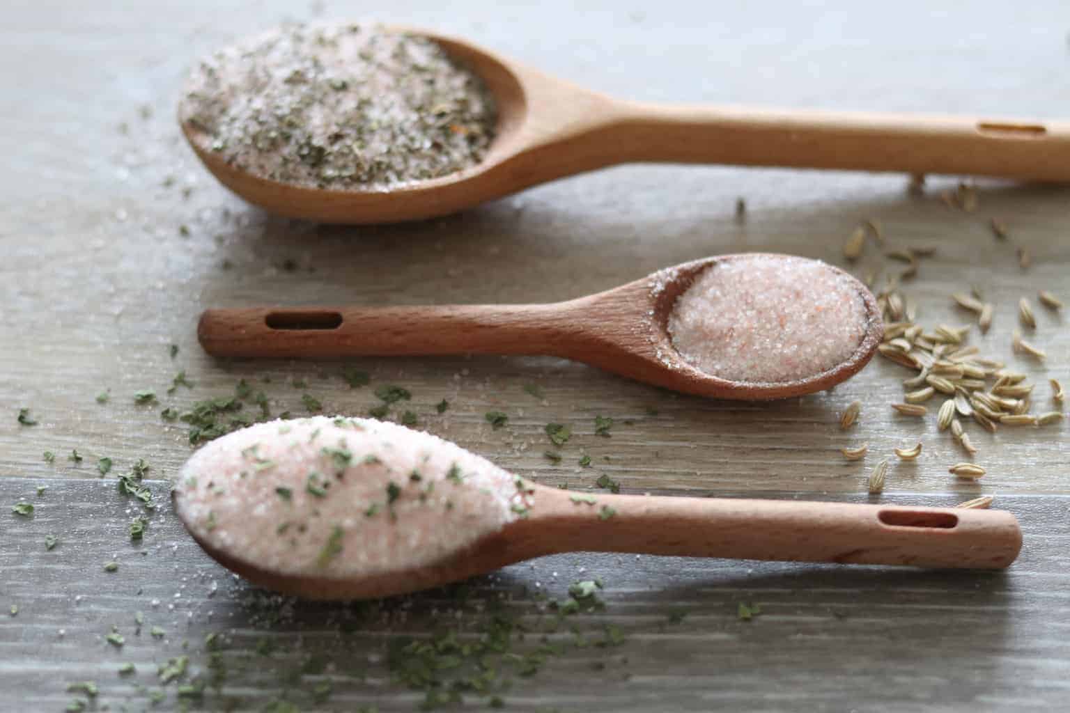 Wooden spoons filled with seasoned salts.