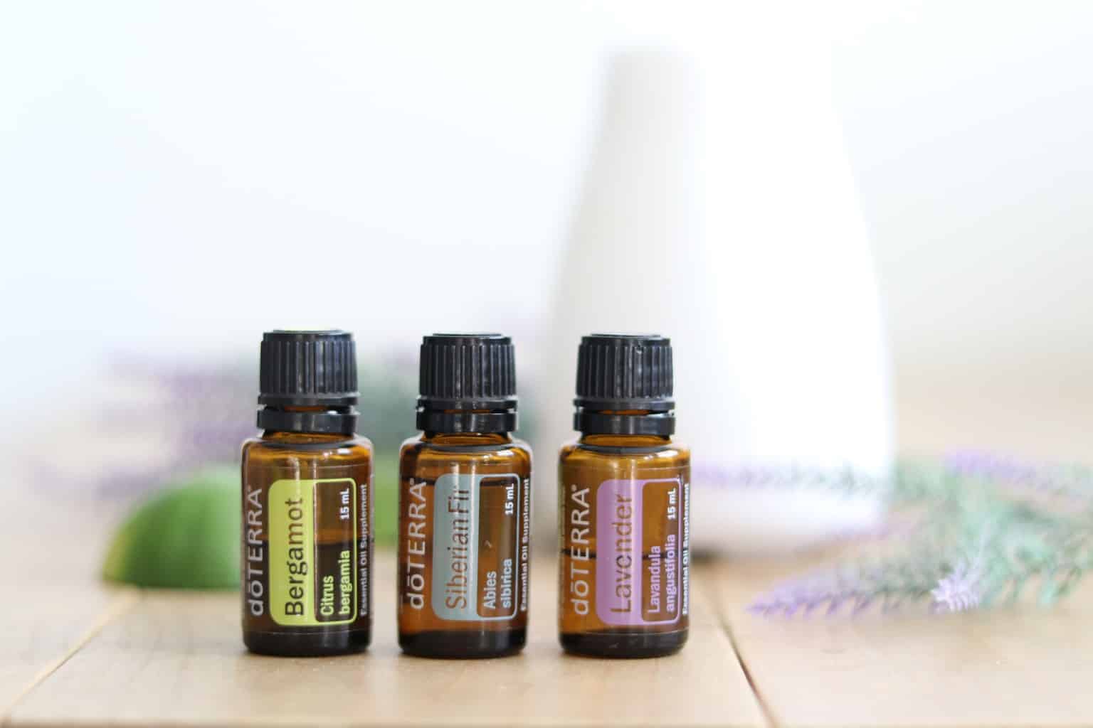 doTERRA roller bottles on table with diffuser in background. 