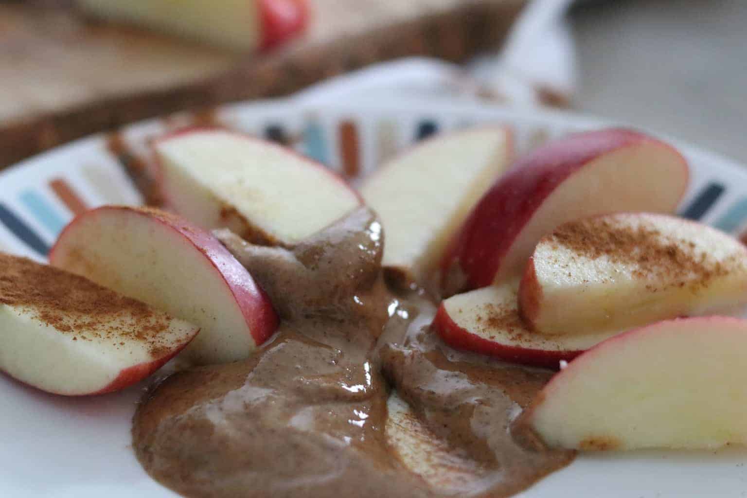 Apples slices and almond butter dip on plate.