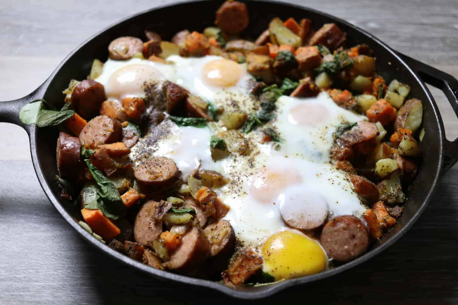 Sausage, sweet potatoes, egg hash in cast iron skillet.