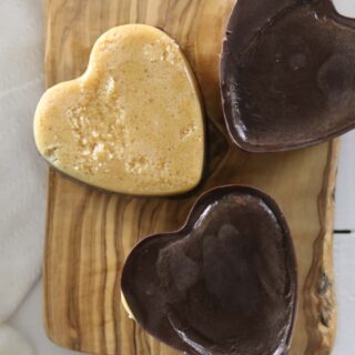 Peanut butter chocolate hearts on a wooden table.