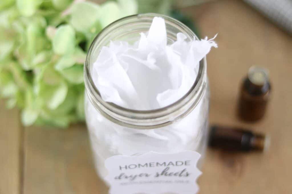 DIY dryer sheets with reusable sheets on wooden folding table.