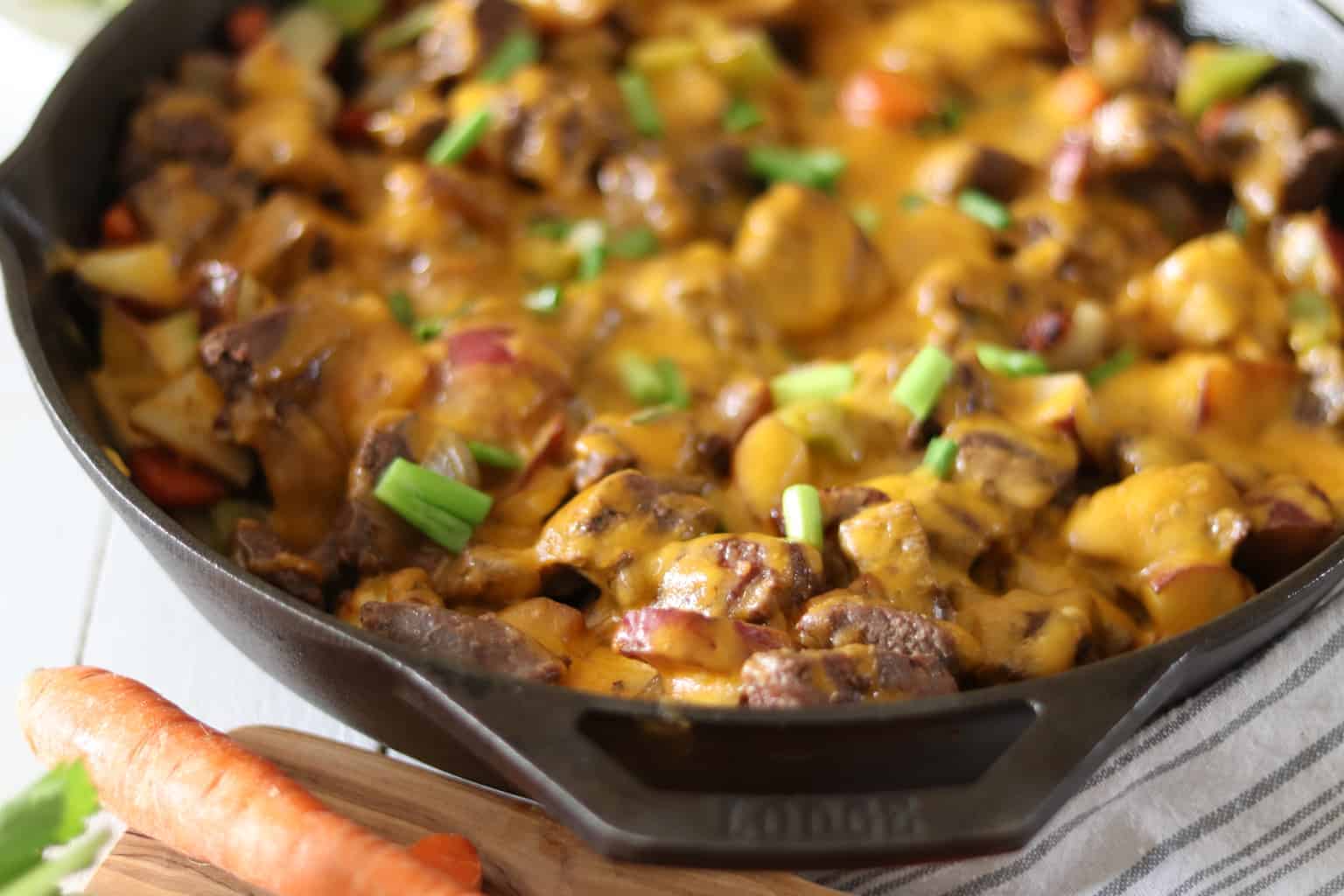 Simple cast-iron skillet meal topped with cheese and green onions.