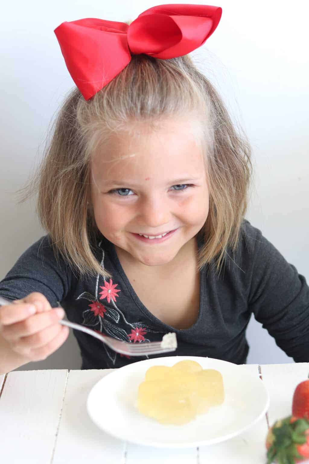 Adorable little girl eating healthy jello.