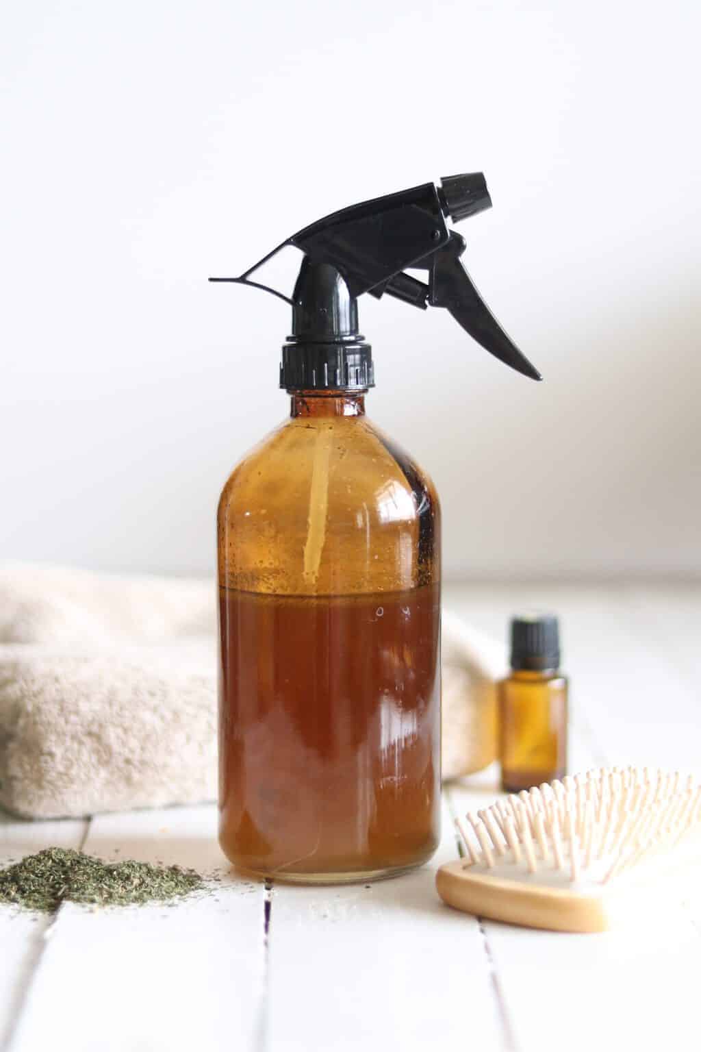 Amber spray bottle of hair serum with essential oils.