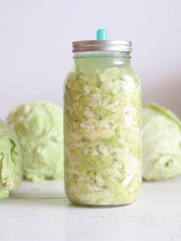 Letting the sauerkraut ferment in a tall glass jar.
