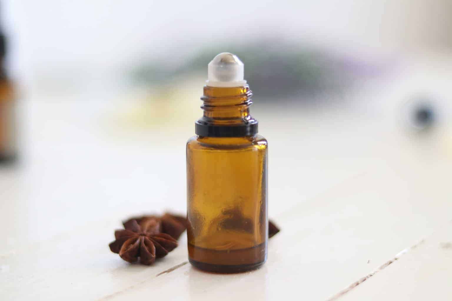 Amber color roller bottle on white wooden table.