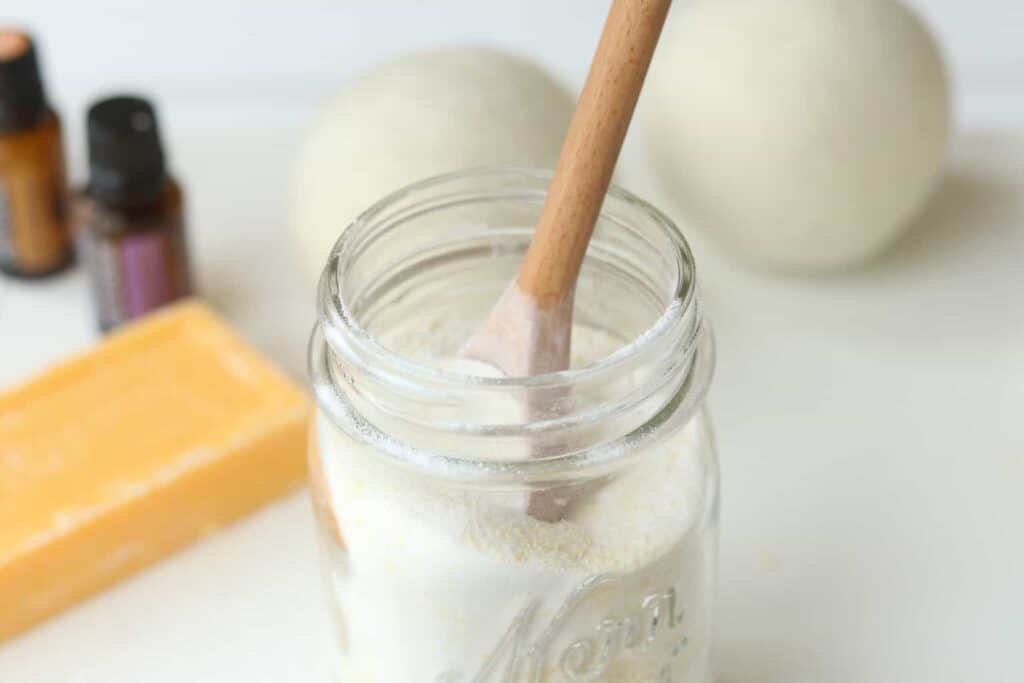 Powder laundry soap in mason jar with wooden spoon.