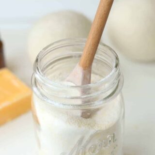 Powder laundry soap in mason jar with wooden spoon.